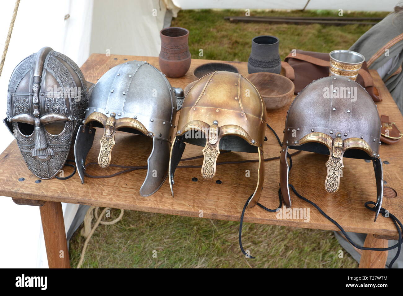 Caschi anglosassone allineate su un tavolo a una storia viva evento nel Suffolk, Regno Unito Foto Stock