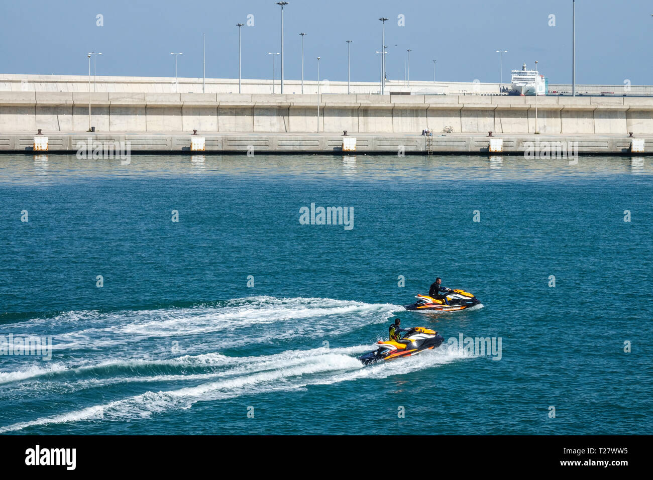 Due uomini alla guida di una moto d'acqua e ingresso al porto tranquillo di Valencia, Spagna Foto Stock