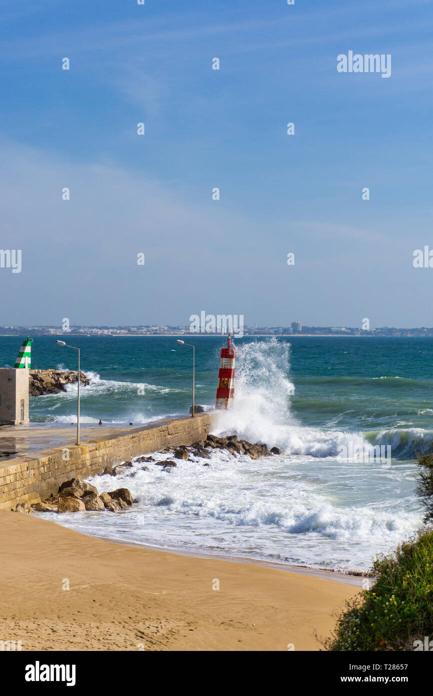 Spruzzi d'onda contro il faro in Lagos, Portogallo Foto Stock