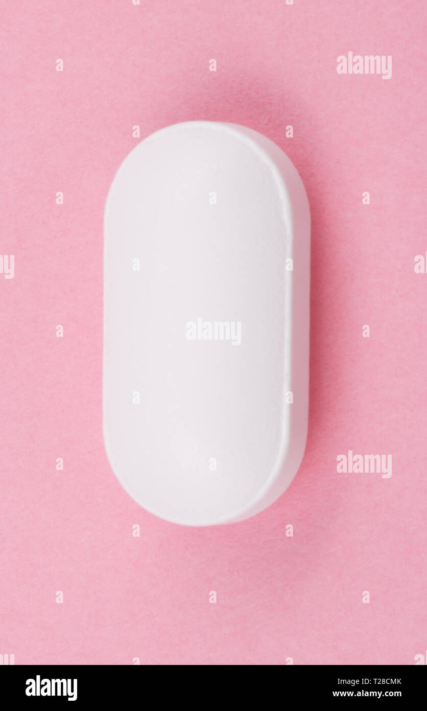 Pillola bianco su sfondo rosa Foto Stock