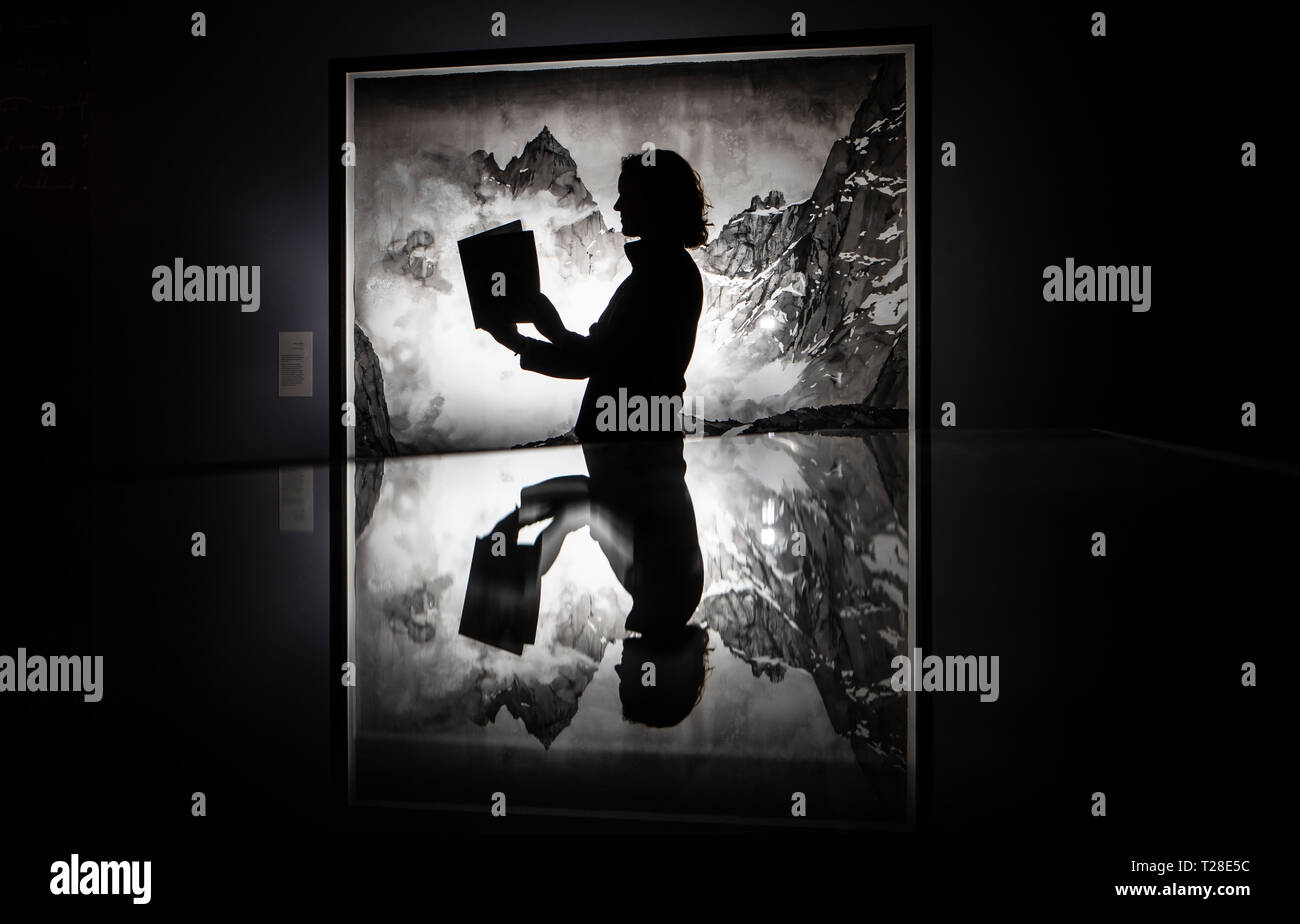 Assistente galleria Emma Woolfrey legge un programma espositivo come ella si è riflessa in una vetrina di fronte a un lavoro di artista Emma Stibbon, parte del Ruskin, Turner e la tempesta Cloud: acquerelli e disegni mostra che ha aperto questo weekend al York Galleria d'arte. Foto Stock