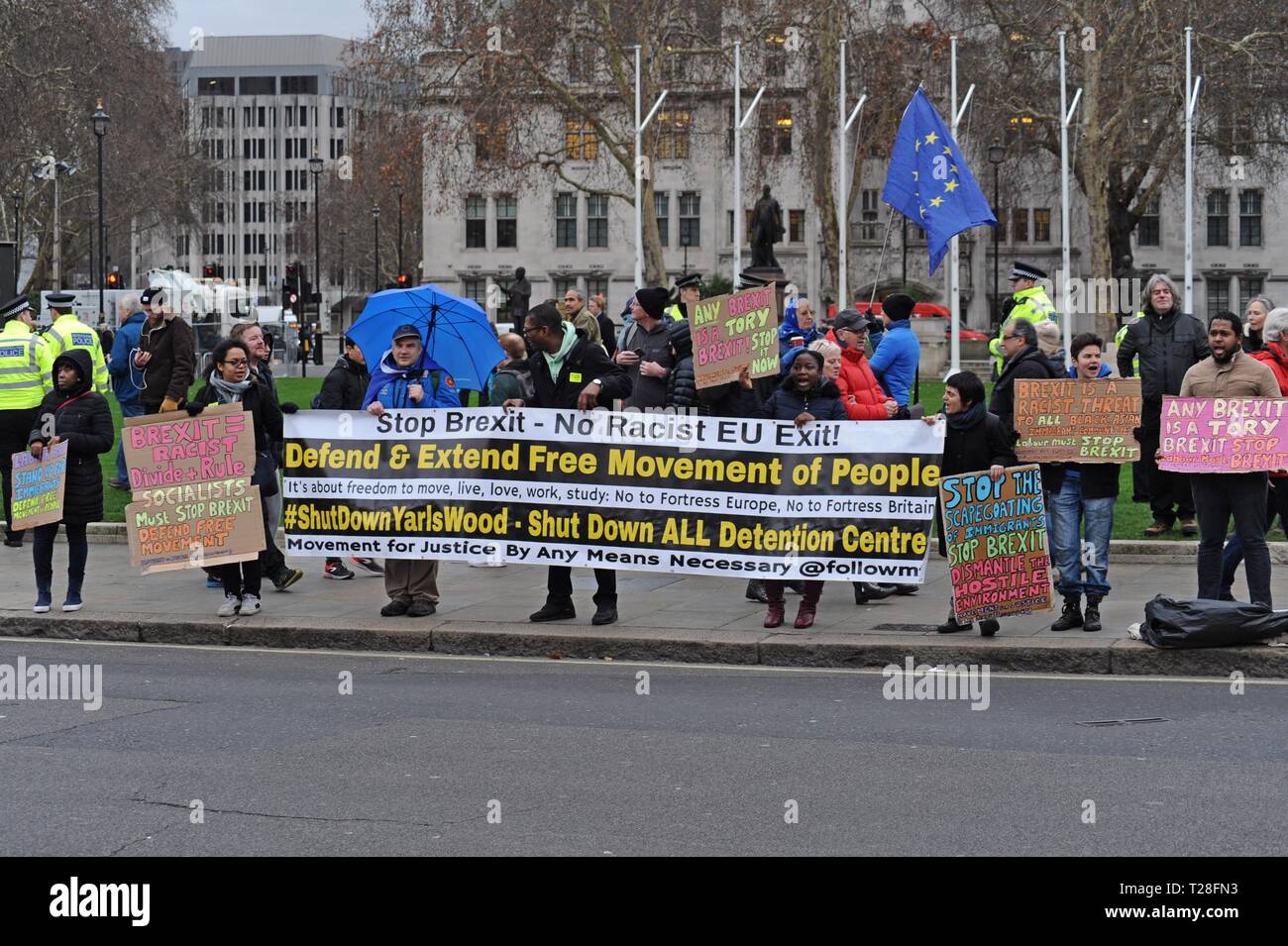 Rimanere e anti razzista difensori tenere cartelli in piazza del Parlamento, Westminster al Parlamento per il suo voto significativo XV Gennaio 2019 Foto Stock