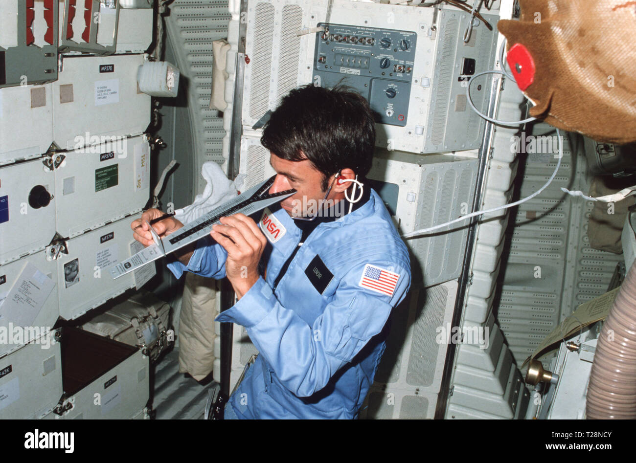 (11-16 nov. 1982) --- astronauta William B. Lenoir, STS-5 specialisti di missione, controlli la sua visione utilizzando diottra dispositivo di misurazione sul middeck di fronte allo sviluppo di strumenti di volo (DFI) unità. Foto Stock