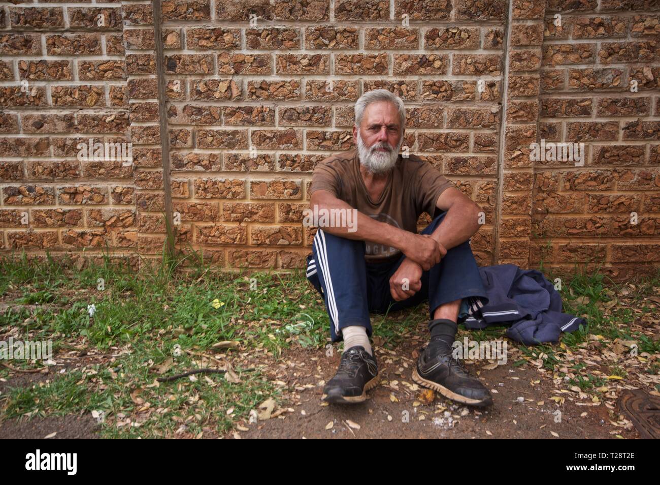 Al di fuori del centro di lavoro bianco invecchiato sud africano, seduto sulla strada, Johannesburg, Sud Africa Foto Stock