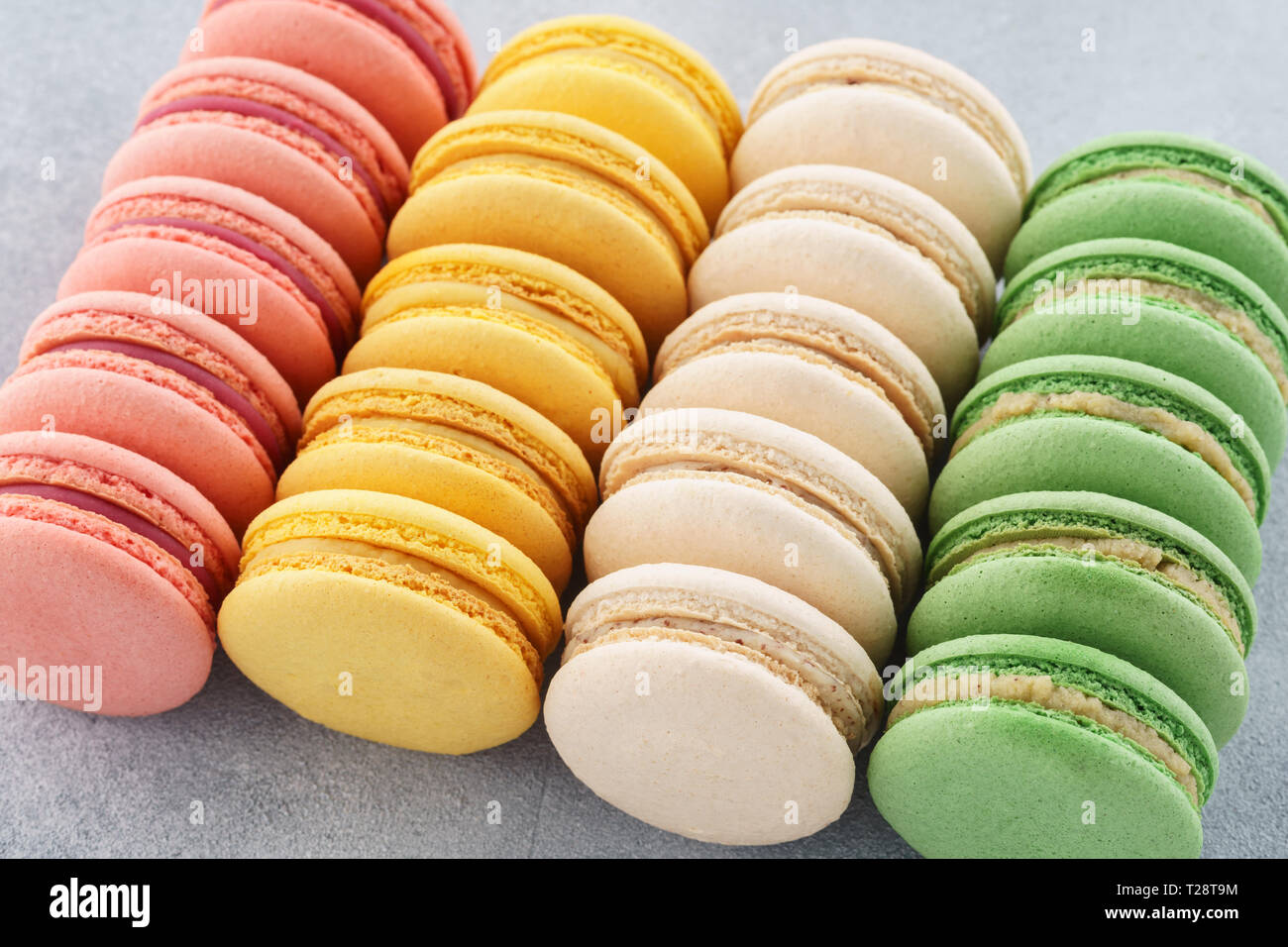 Righe di vari colorati macarons francese su sfondo grigio. Foto Stock