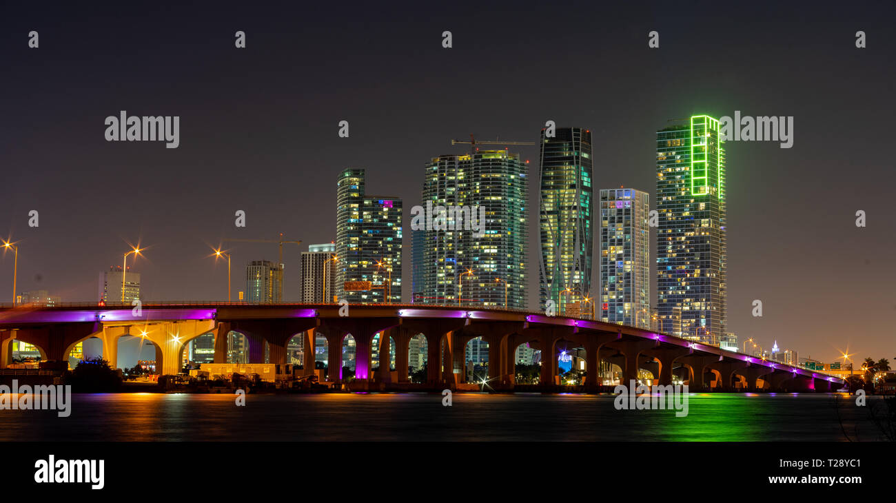 Tempo di notte vista della città di Miami e Bay Area. MacArthur Causeway cercando splendida rosa con luci al neon. Presi dalle isole Venetial Foto Stock