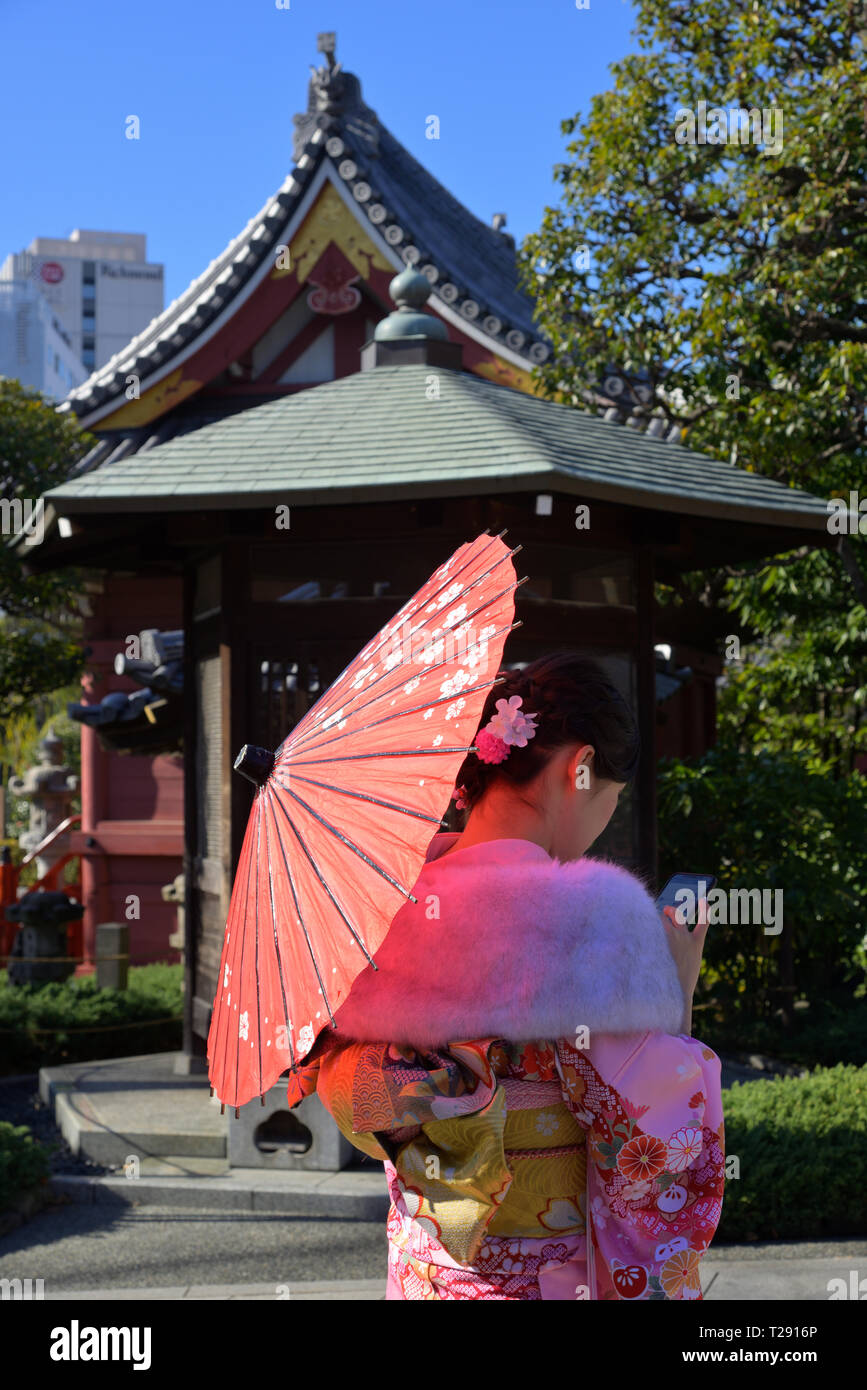 Una donna Kimono si è rivestita guardando il suo cellulare, Asakusa senso-ji JP Foto Stock