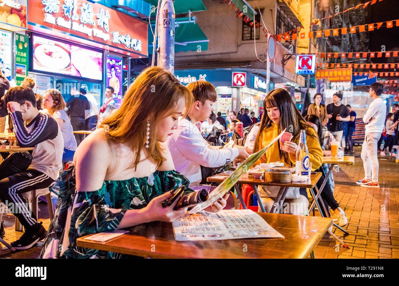 Un folto gruppo di persone, rilassarsi e socializzare presso il Mercato Notturno di Temple Street, Hong Kong Foto Stock