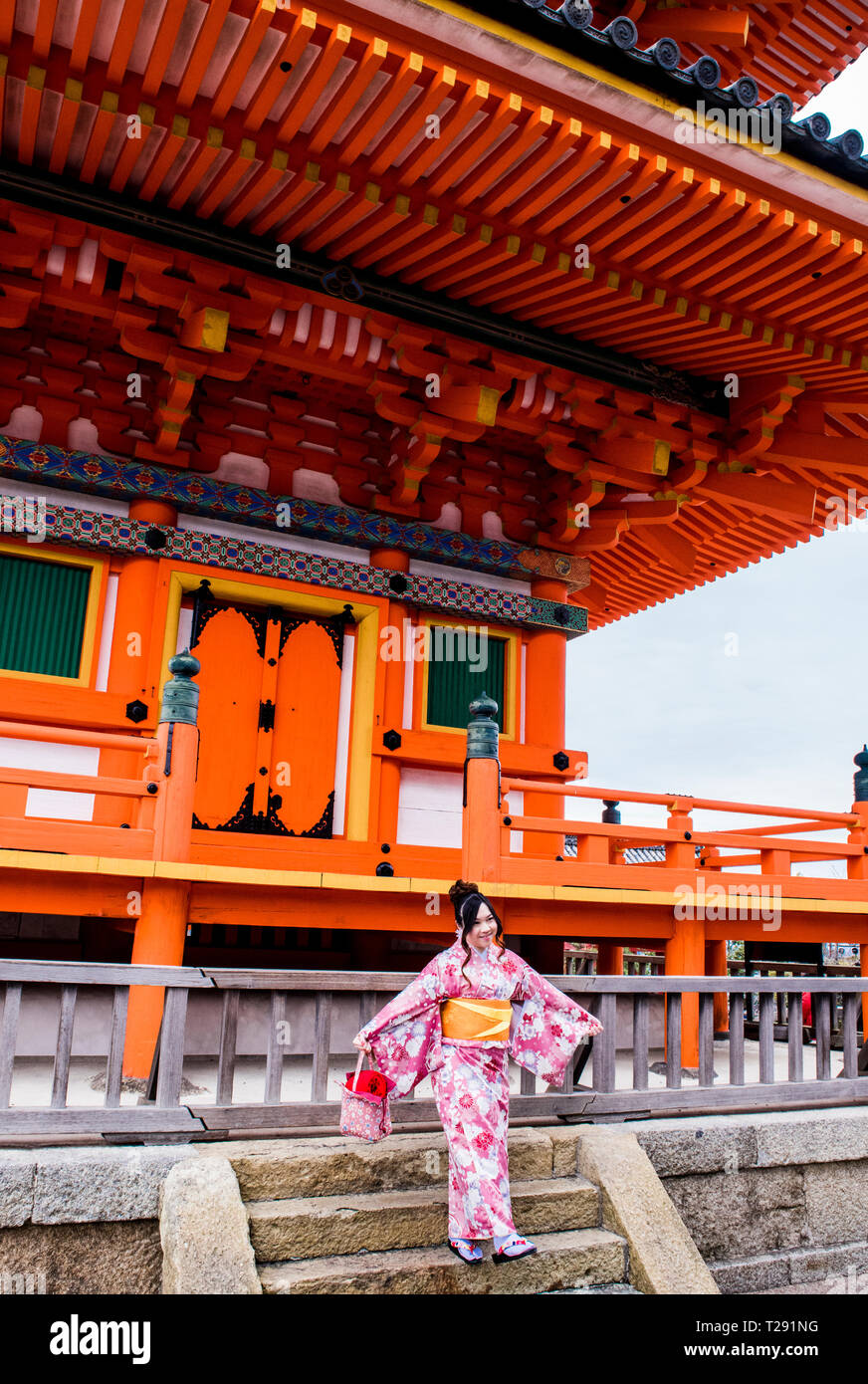 Ritratto di donna in abito tradizionale, stando in piedi sui gradini davanti di Kiyomizu-dera tempio, Kyoto, Giappone Foto Stock