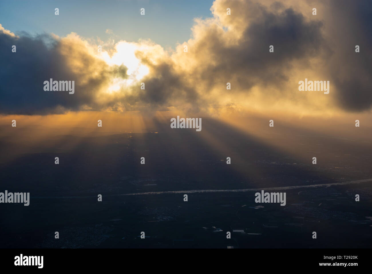 Raggi di sole che attraverso le nubi sulla terra della sera Foto Stock
