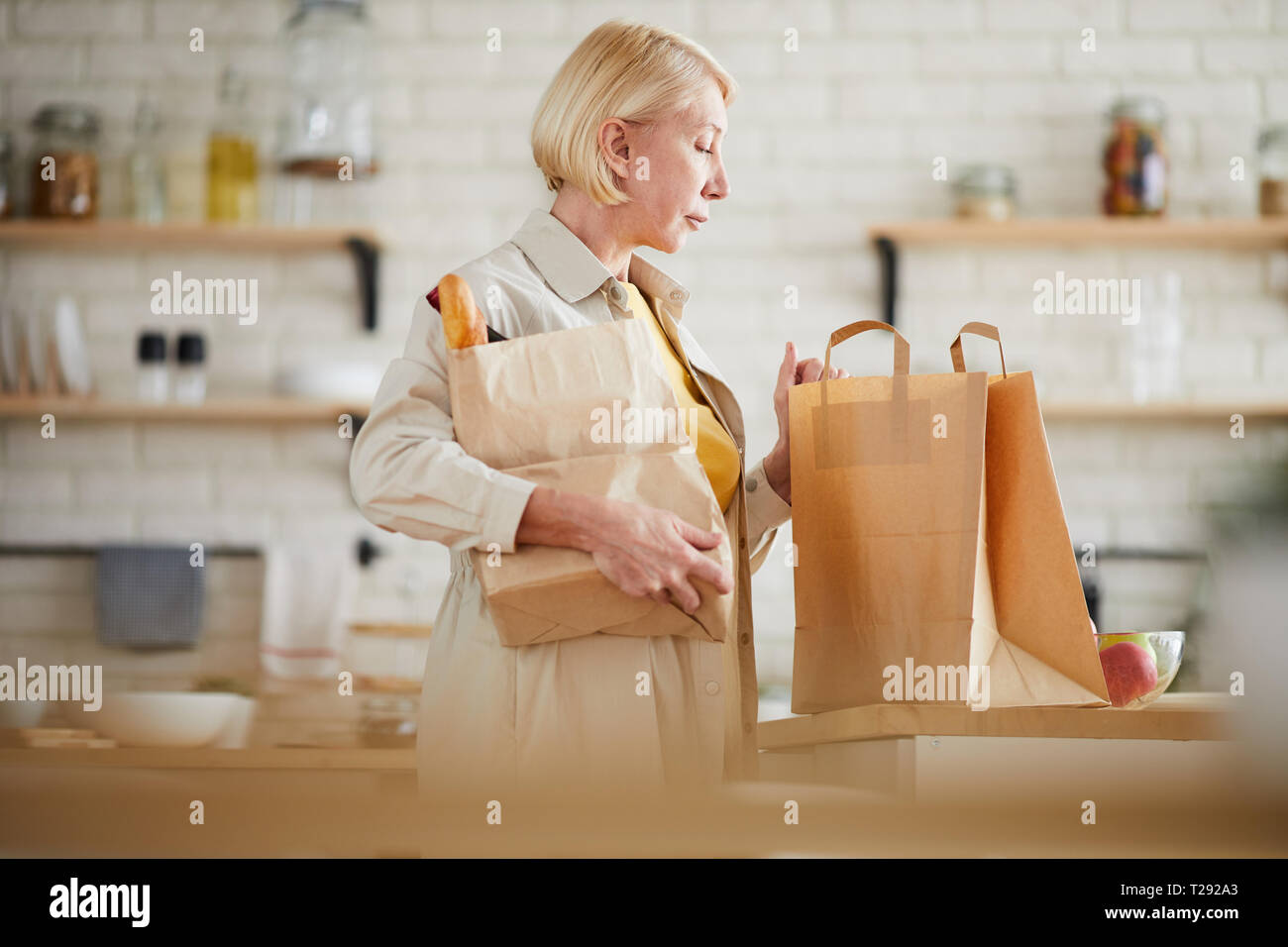 Donna matura tornando a casa dopo lo shopping nel negozio di alimentari Foto Stock