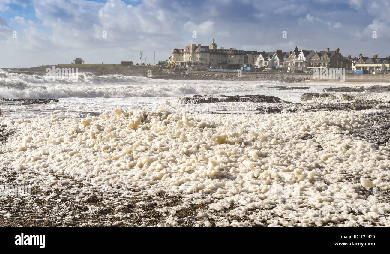 PORTHCAWL, GALLES - Settembre 2018: masse di schiuma di mare che soffia sulla spiaggia in Porthcawl come la marea entra in Foto Stock