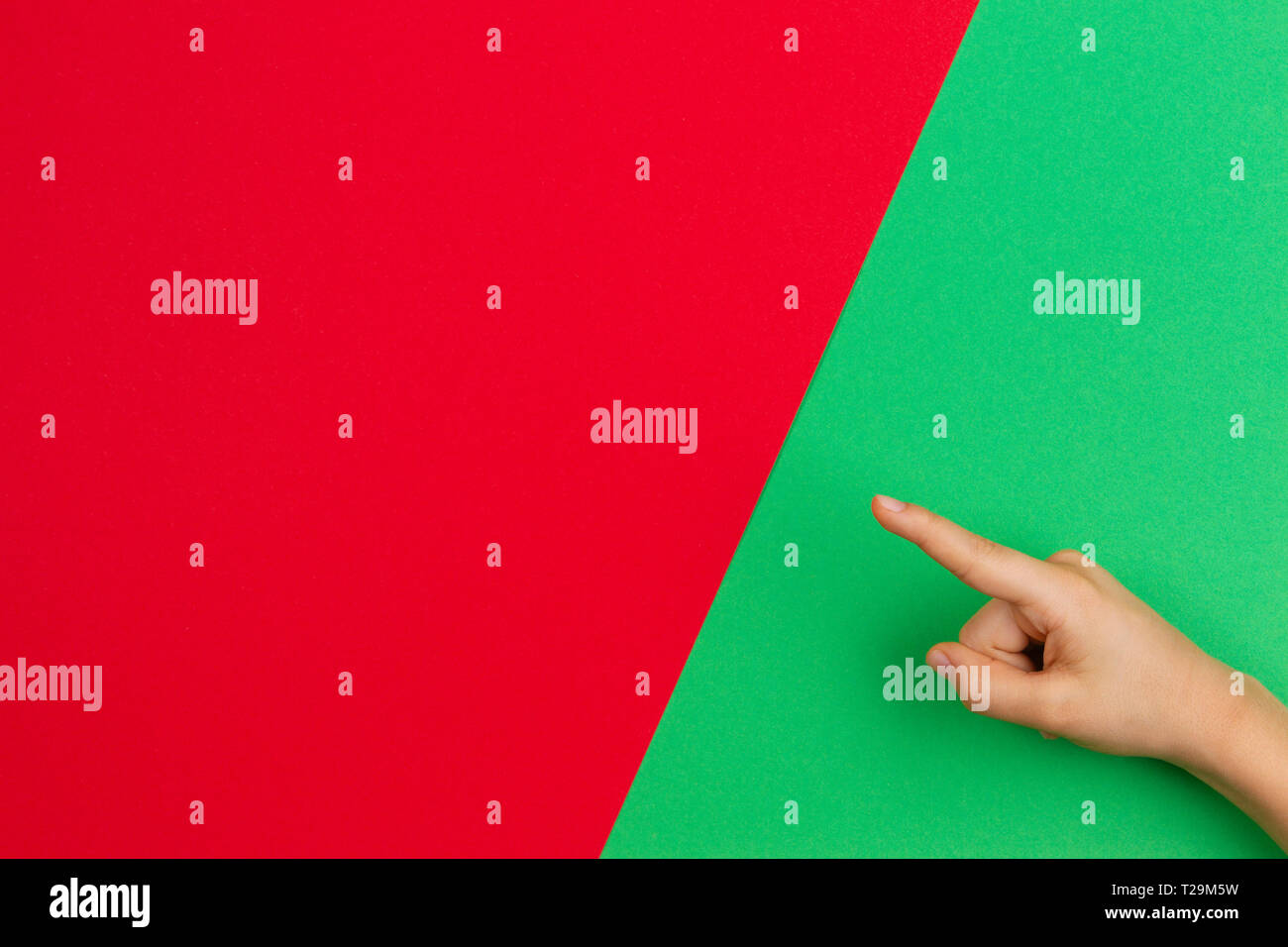 Mano puntando il dito sul verde e rosso e colore di sfondo Foto Stock