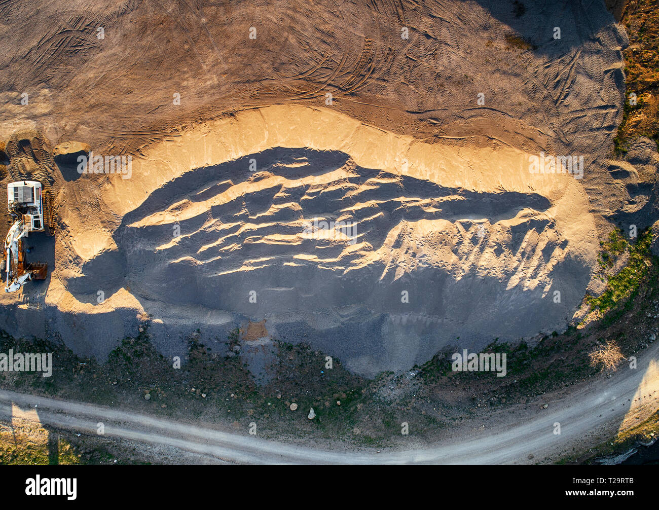 Vista panoramica al tramonto della cava di ghiaia,mining di costruzione gialla ghiaia, ghiaia di pompaggio con l aiuto di potenti pompe, post-apocalittico landscapе Foto Stock