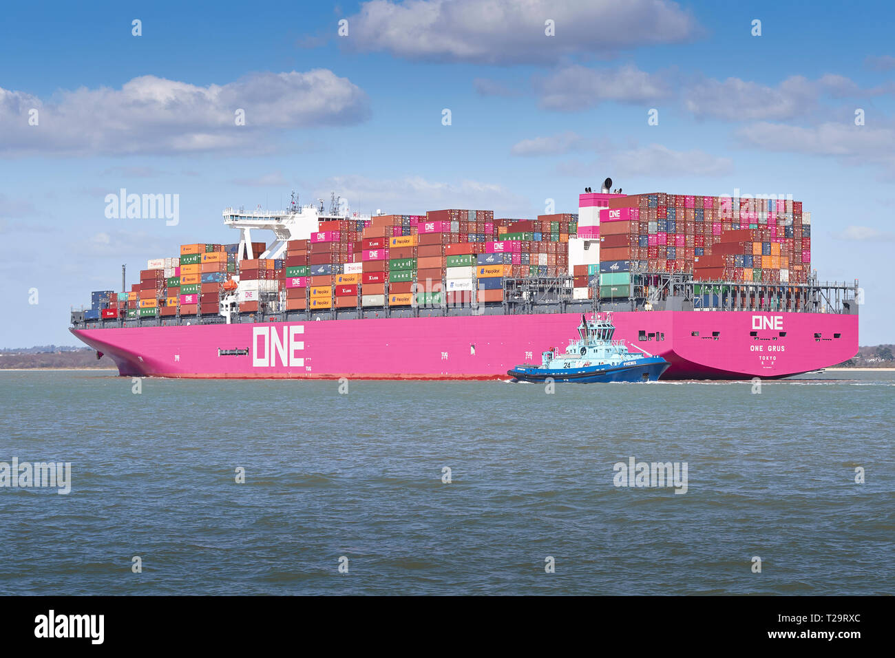 Rimorchiatore Guide PHENIX la nuova rete Ocean Express di portacontainer, uno GRUS, con il distintivo scafo Magenta, come ella si avvicina a Southampton Docks. Regno Unito. Foto Stock
