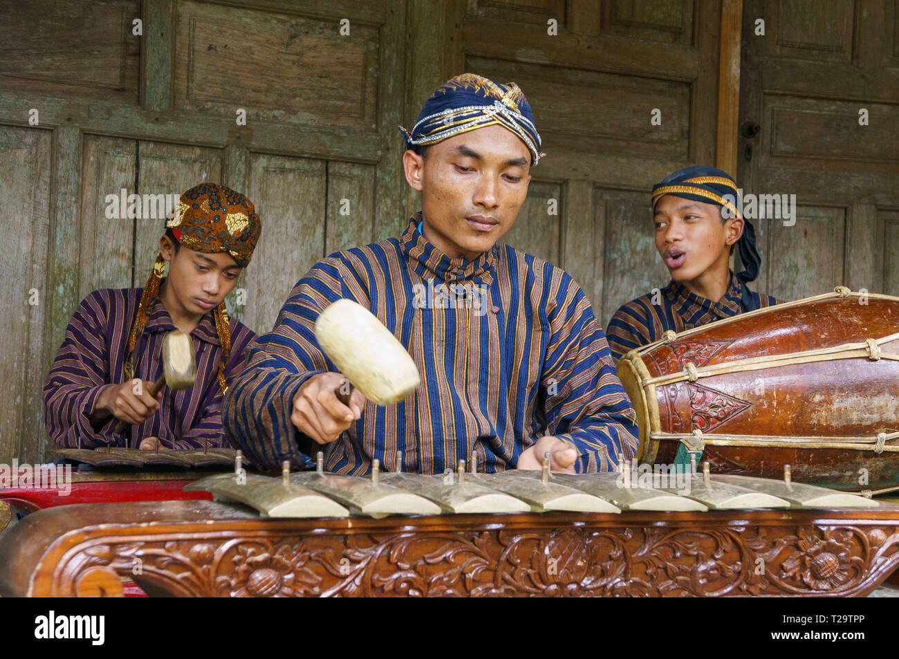 Un gruppo di giovani la riproduzione di gamelan giavanese con utilizzando blangkon, lurik e abiti tradizionali Foto Stock