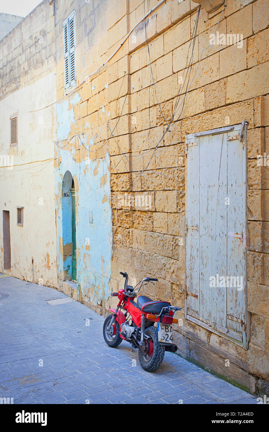 Motocicletta rossa accanto al vecchio muro Foto Stock