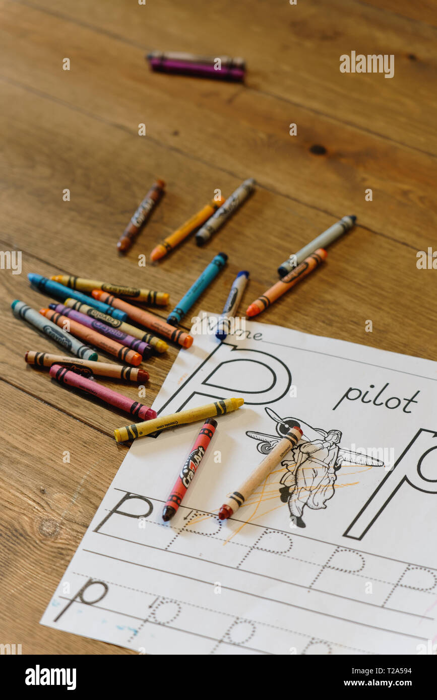 Ellicott City, MD - Marzo 9, 2019: Crayola e Cra-Z-Art matite colorate sono su una tavola di legno con un alfabeto pratica libro da colorare pagina nella messa a fuoco selettiva. Foto Stock