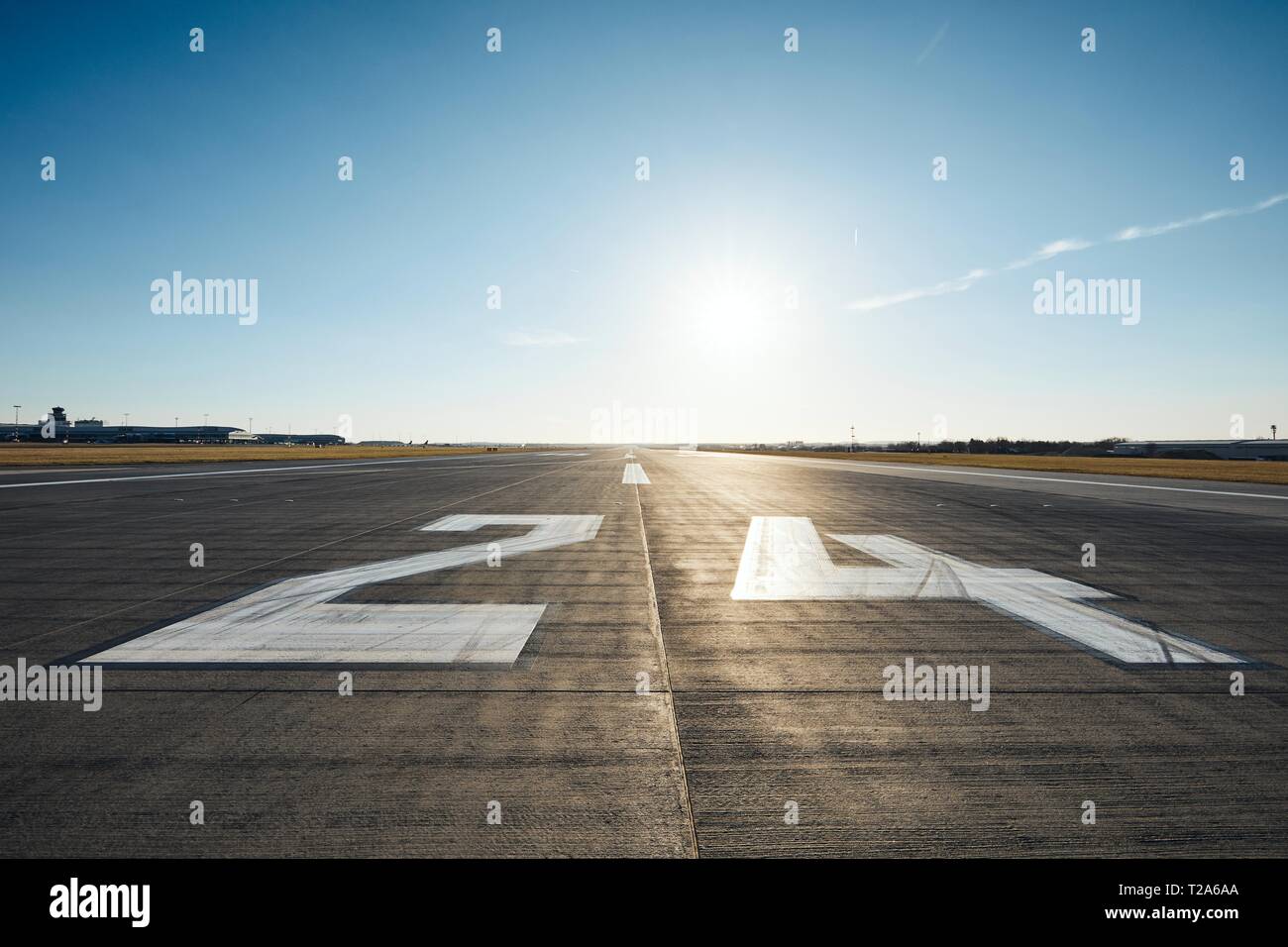 Livello di superficie della pista di aeroporto con la segnaletica stradale e il numero 24 contro il cielo chiaro. Foto Stock