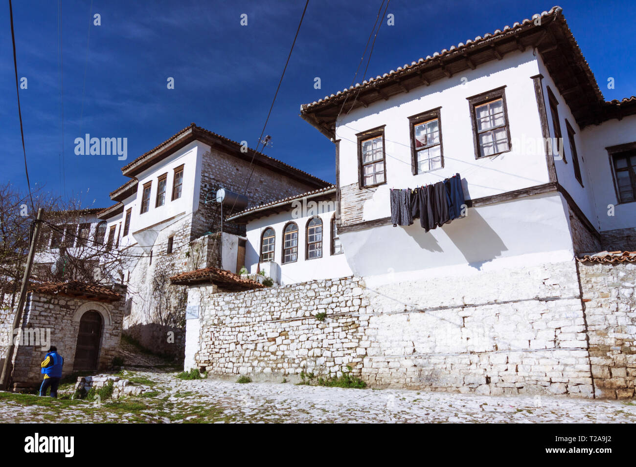 Berat, Albania : un uomo cammina passato vecchio stile ottomano edifici all'interno del distretto Kalaja, un quartiere residenziale all'interno della vecchia cittadella bizantina e p Foto Stock