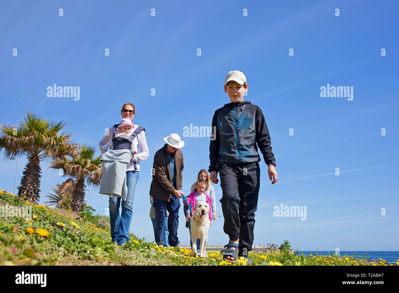 Una famiglia e il loro cane a camminare lungo la passeggiata, Sea Point, Città del Capo. Foto Stock