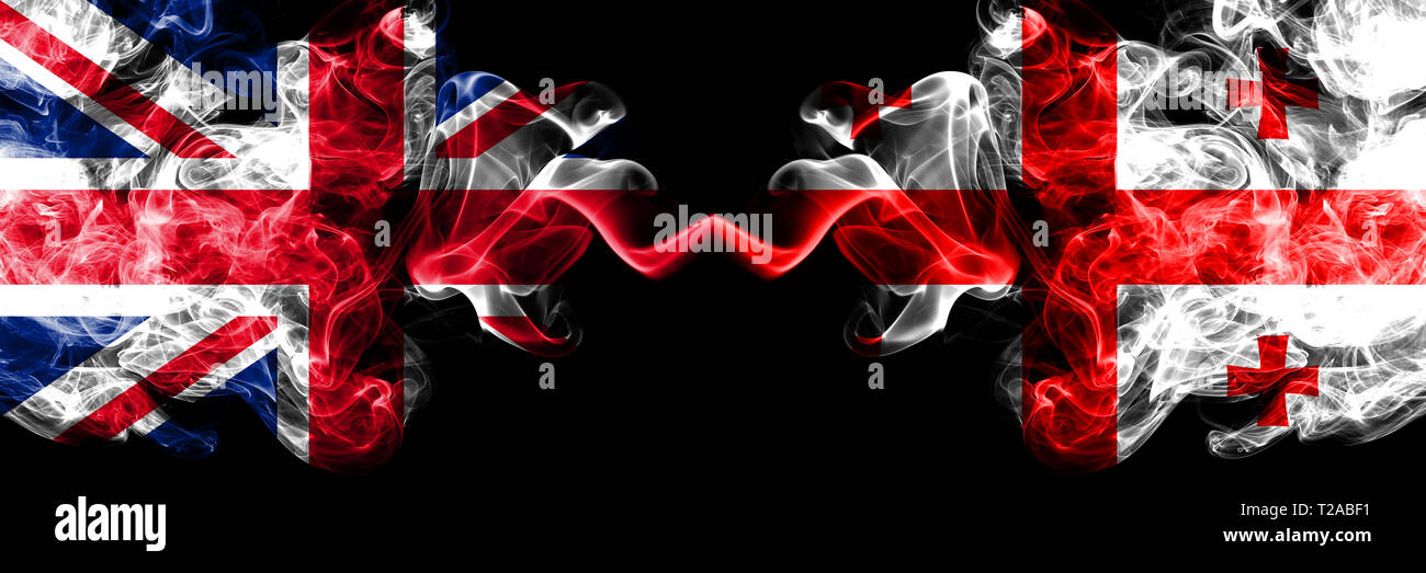 Regno Unito vs Georgia, Georgiano smoky mystic bandiere poste fianco a fianco. Spessa colorata fumo setosa bandiere di Gran Bretagna e Georgia, Georgiano. Foto Stock