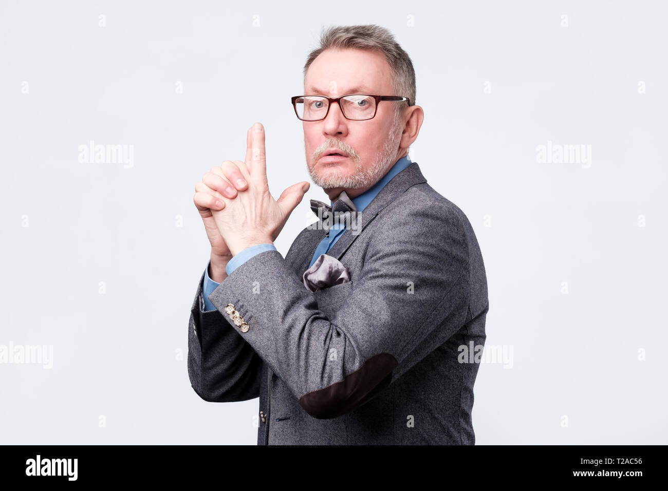 Senior uomo dicendo che ho fatto, fingendo che egli è in possesso di una pistola. Hey, tutto è fatto perfettamente Foto Stock