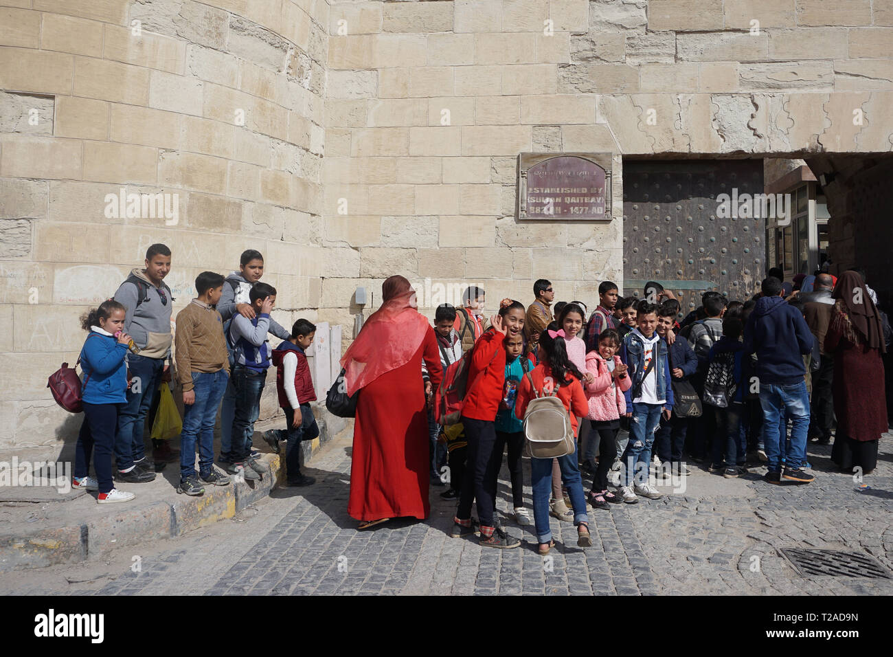 Alessandria, Egitto: egiziana scuola bambini attendere per immettere la cittadella Qaitbay, stabilito dal Sultano Qaitbay nel 1477 Annuncio sul isola Pharos. Foto Stock
