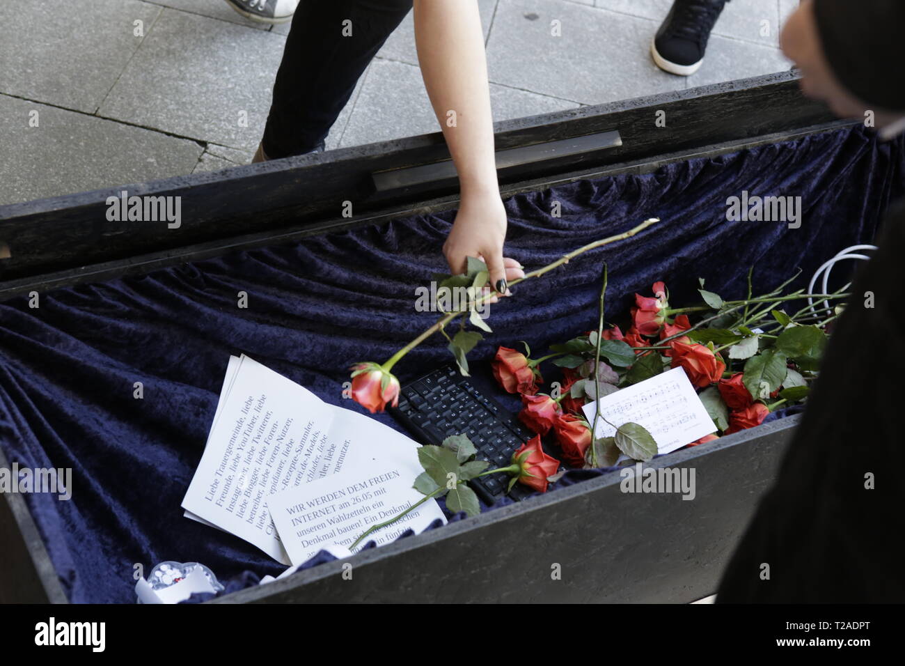 Francoforte, Germania. 30 Mar, 2019. Un mourner luoghi un fiore nella bara aperta. Circa un centinaio di persone hanno marciato attraverso il centro di Francoforte, a piangere la connessione Internet gratuita, dopo che il Parlamento europeo ha votato a favore della direttiva sul diritto d'autore. Stavano portando una bara e erano lettura elogi per Internet. Credito: Michael Debets/Pacific Press/Alamy Live News Foto Stock