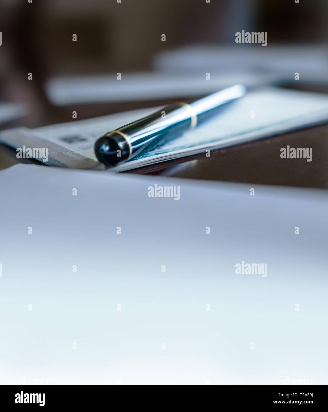 Una penna su un libretto di assegni e carte tutte intorno. Copia dello spazio. Foto Stock