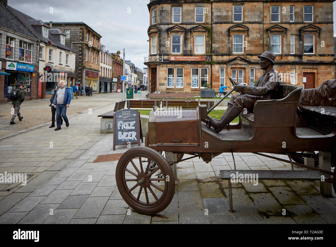 Fort William Town High Street statua in bronzo che commemora il modello T Ford vettura guidata fino Ben Nevis un audace trovata pubblicitaria da Henry Alexander Foto Stock