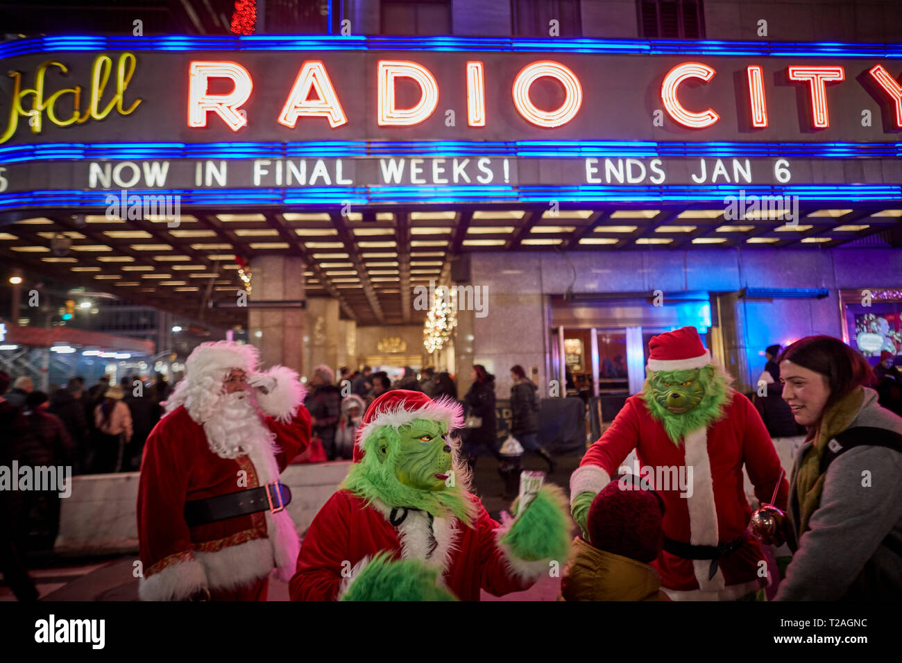 Le decorazioni di Natale Radio City buskers vestiti da Babbo Natale e il Grinch in cerca di consigli , 6th Avenue, Manhattan, New York di notte Foto Stock