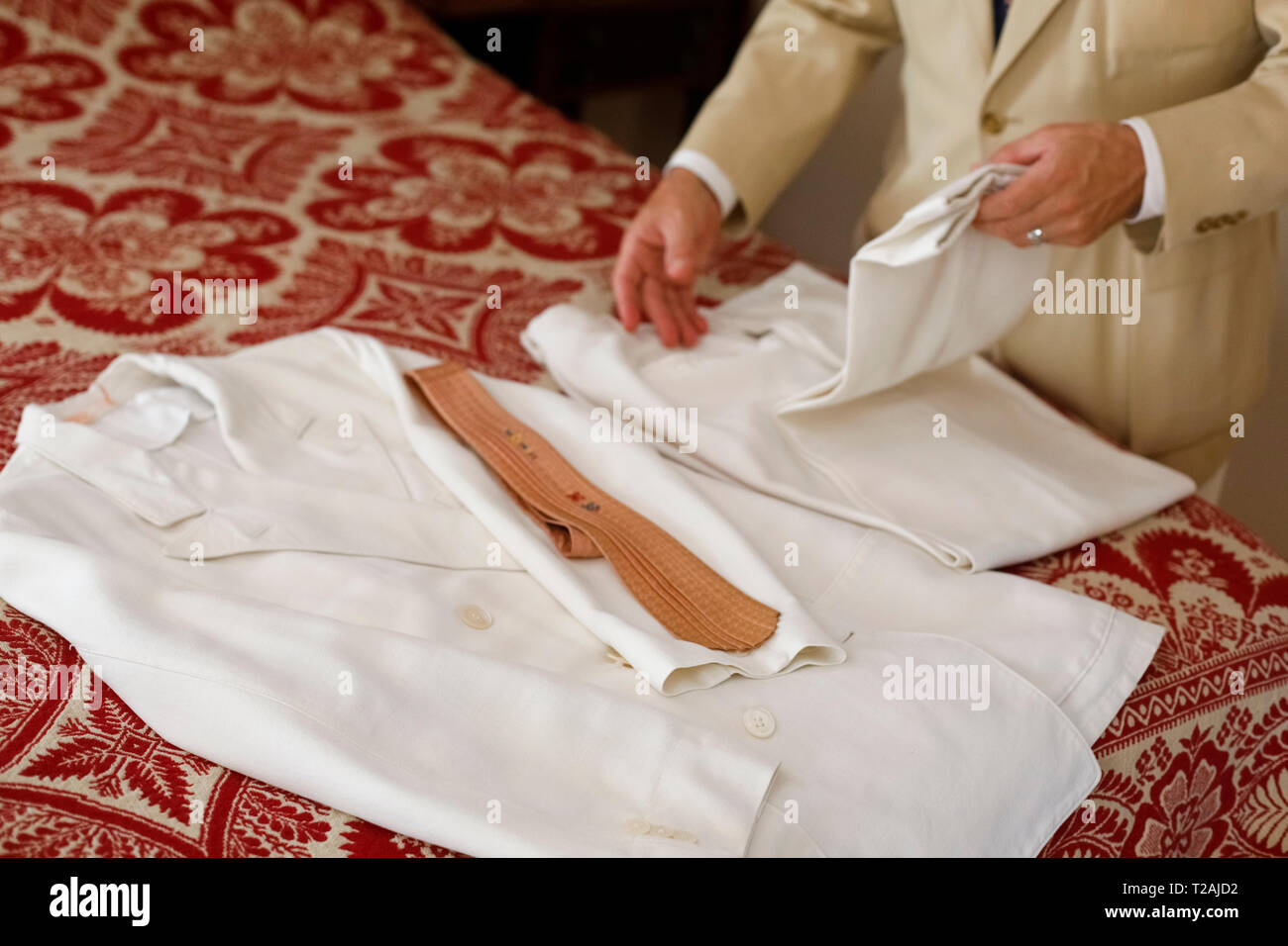 Uomo che piega vintage abito bianco Foto Stock