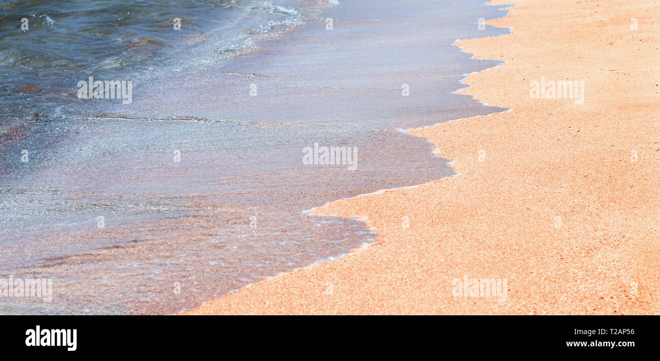 Onda di luce blu del mare su una spiaggia di sabbia. Utile per lo sfondo. Foto Stock