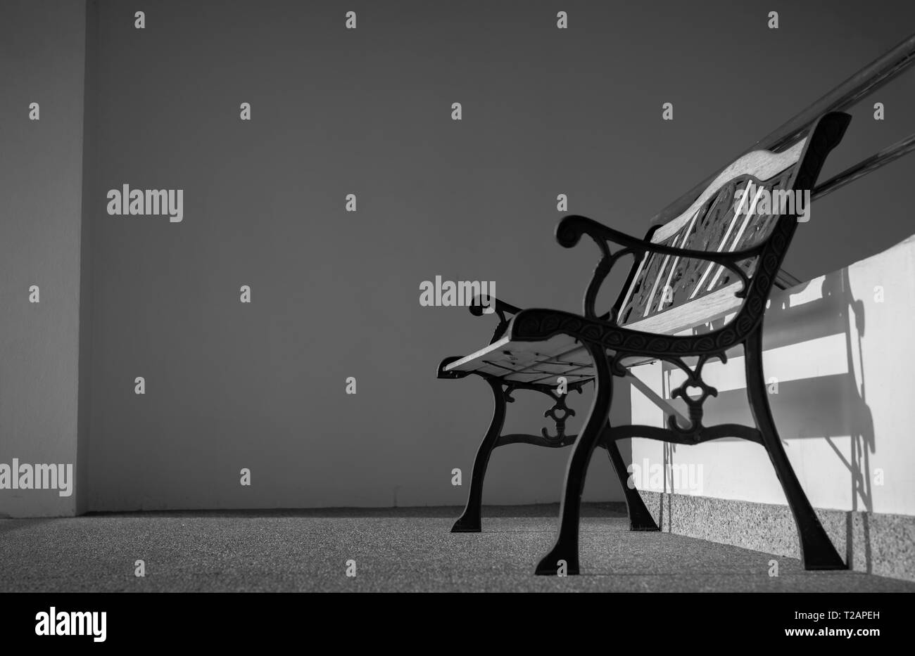 Svuotare il ferro battuto bancone vicino a scale dell'edificio. Il sole in per l'edificio di cemento. Premuto, triste e solitaria concetto. Uno vuoto wrough Foto Stock
