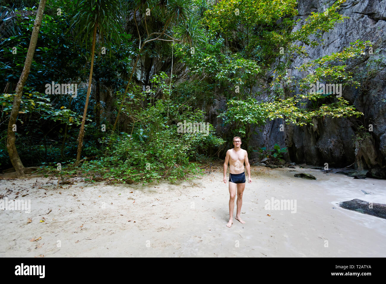 Giovane uomo caucasico nella Grotta dello Smeraldo (Tham Morakot) sulla tropicale Koh Mook island in Thailandia. Paesaggio interno sulla spiaggia. Luna di miele vacanze pho Foto Stock