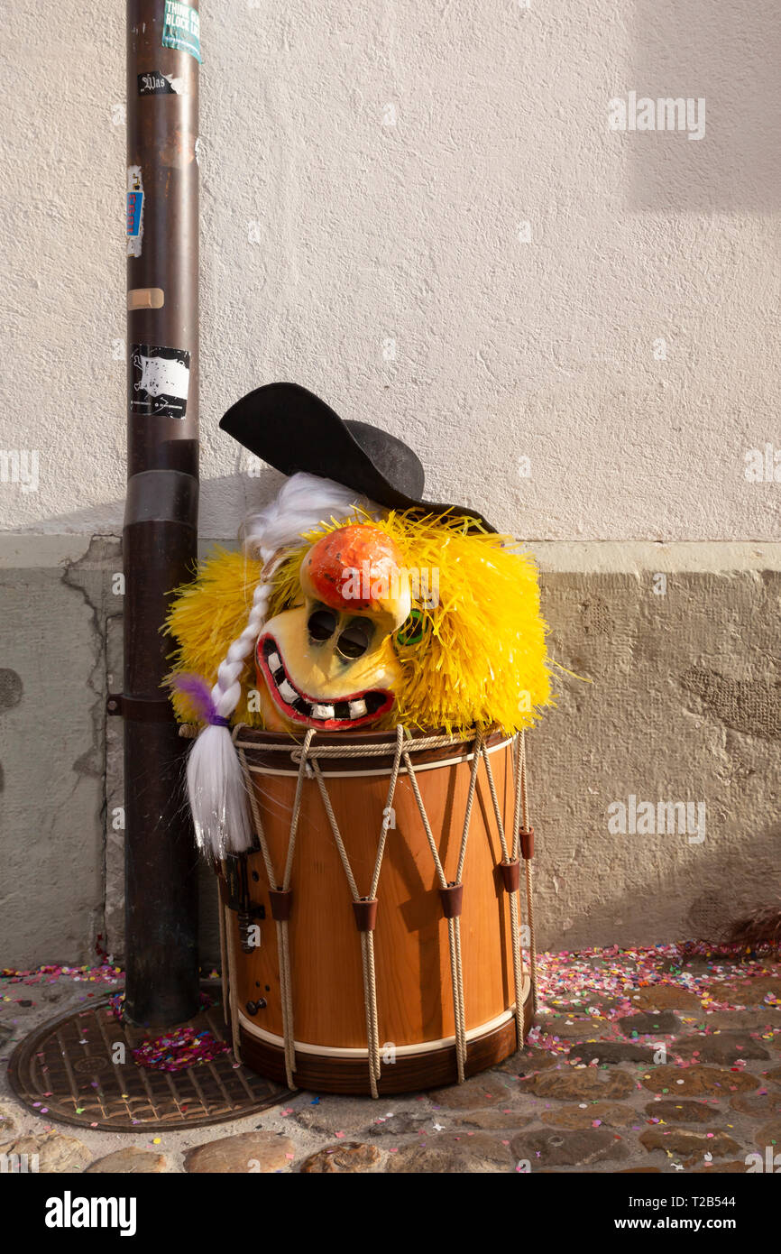 Muensterberg, Basilea, Svizzera - Marzo 12th, 2019. Close-up di un tamburo rullante con una maschera di Carnevale sulla parte superiore Foto Stock