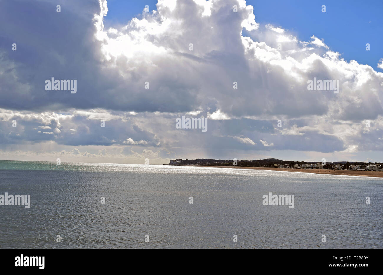 Cielo nuvoloso sopra il mare in inglese con la costa in background Foto Stock