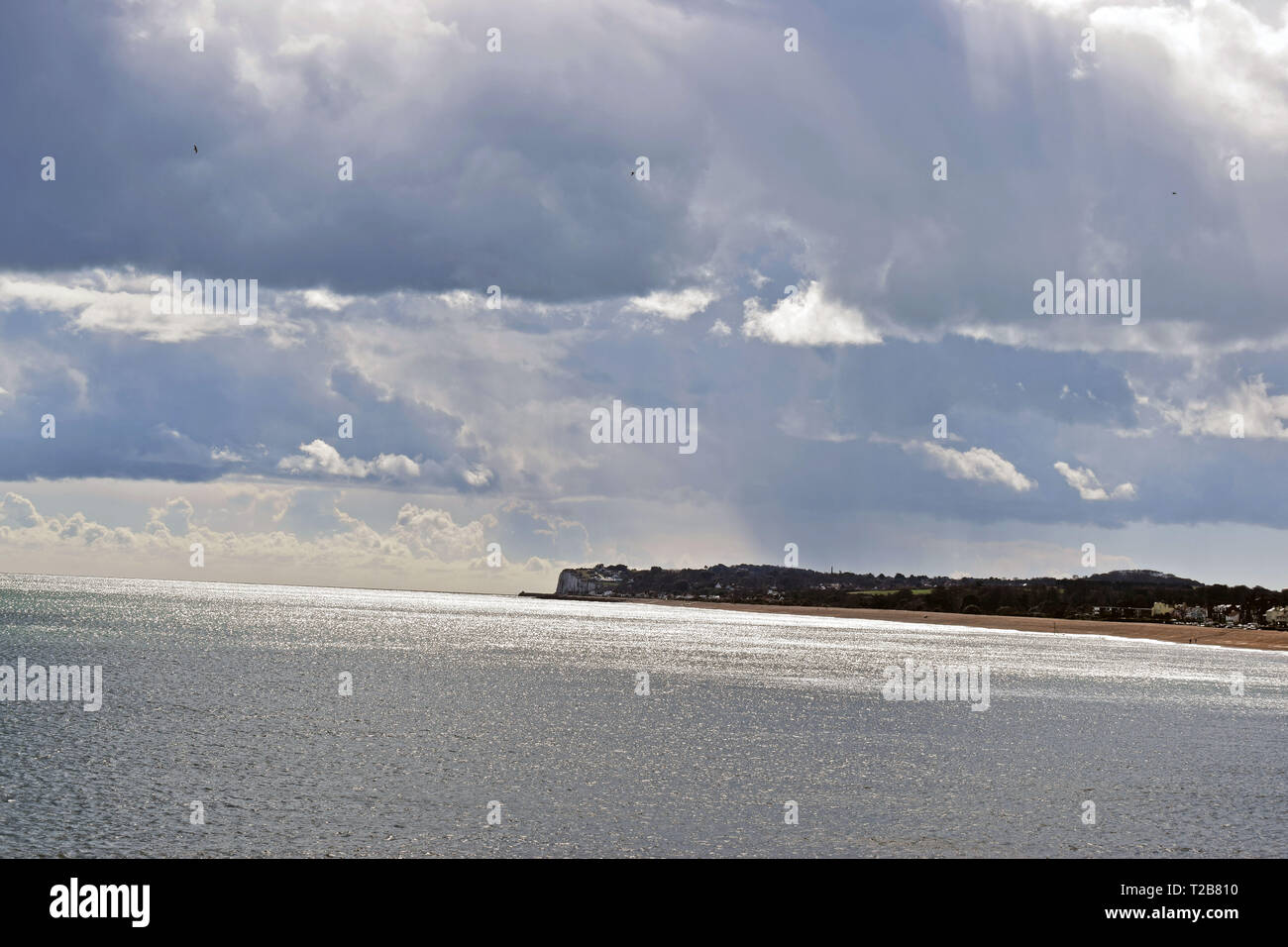 Cielo nuvoloso sopra il mare in inglese con la costa in background Foto Stock