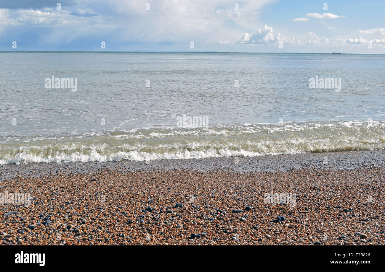 Mare, scena drammatica cielo nuvoloso sul Saint Margaret's Bay con acqua di mare arrivando fino alla spiaggia di ciottoli Foto Stock