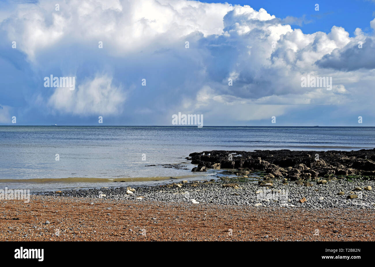 Mare, scena drammatica cielo nuvoloso sul Saint Margaret's Bay con mare arrivando fino alla spiaggia di ciottoli Foto Stock