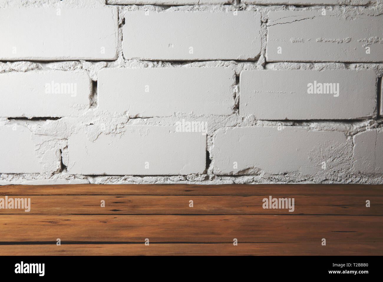 Plank vecchio pavimento in legno con il bianco muro di mattoni Foto Stock