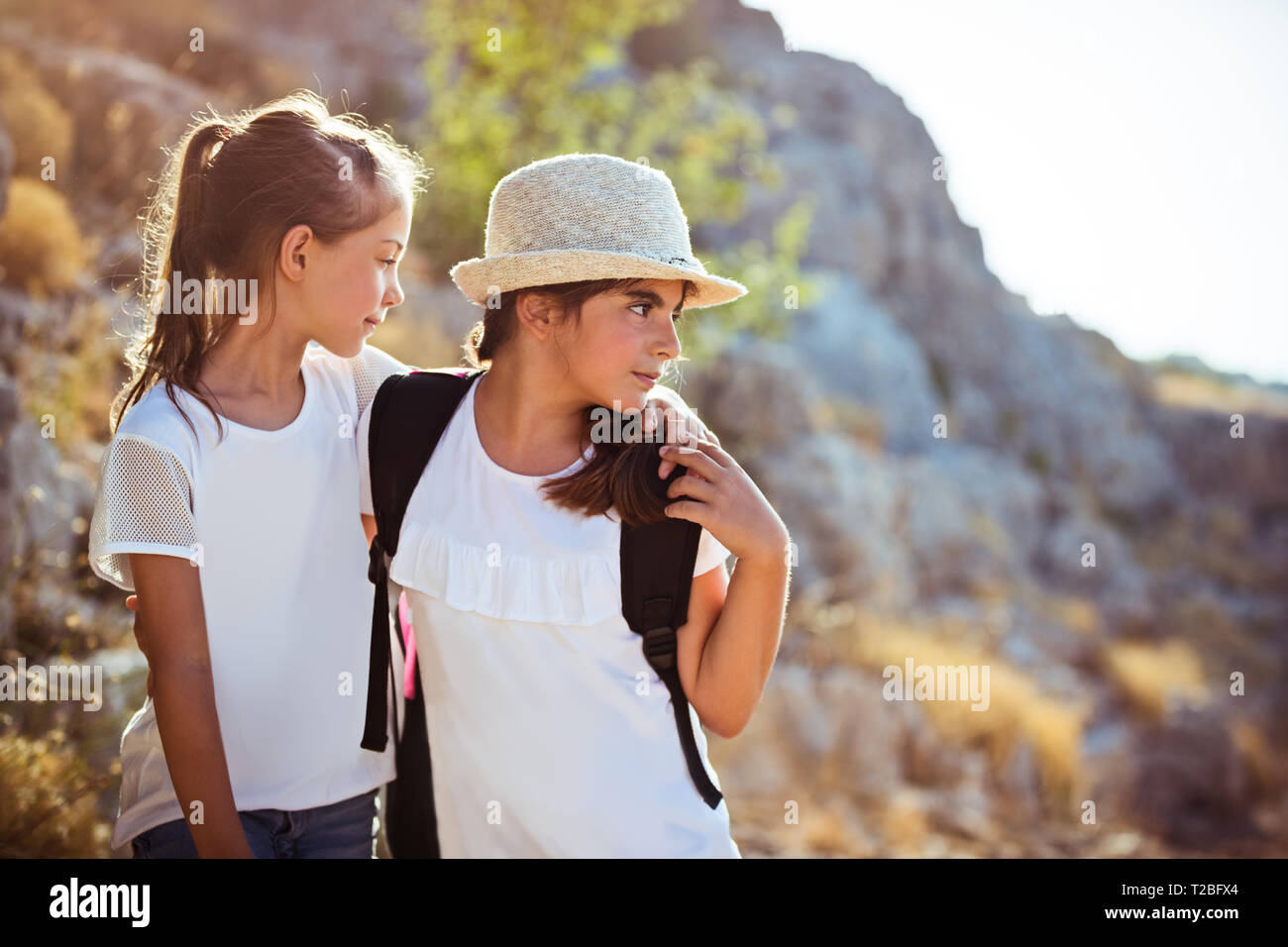 Due ragazze della scuola con zaini che viaggiano lungo le montagne, con il piacere di trascorrere del tempo in un sportive summer camp Foto Stock