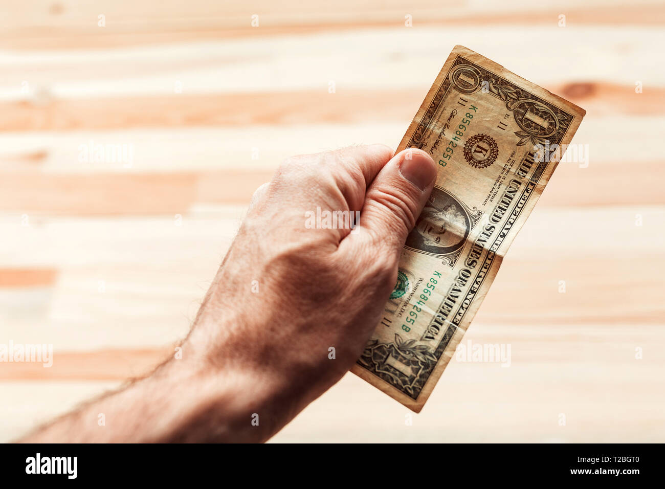 Uomo di pagare con un dollaro USA Bill, close up dei maschi di mano azienda americana valuta della carta Foto Stock