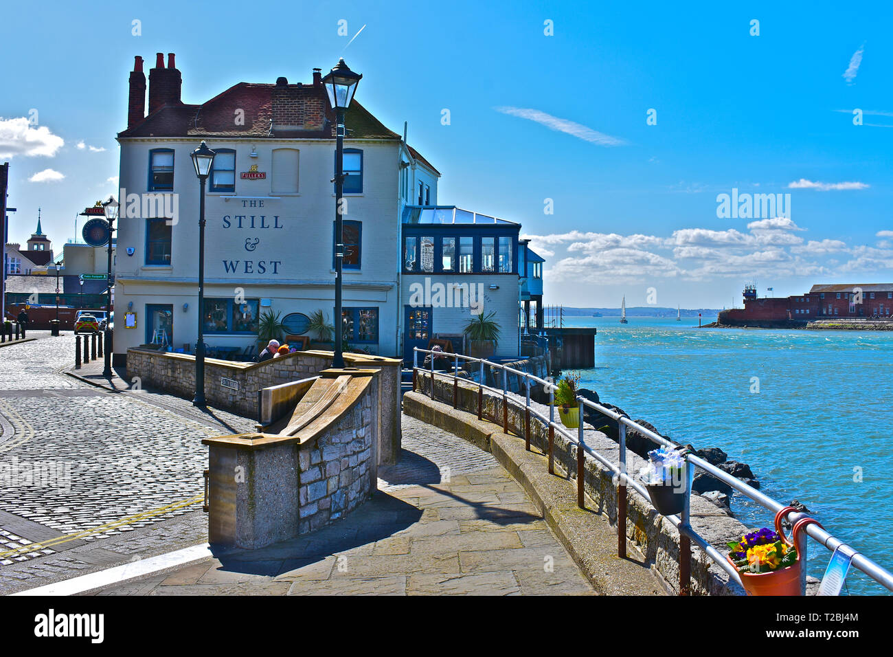 Il 'Still & West' è un gualchiere public house situato di fronte l'ingresso al porto di Portsmouth. Sole primaverile. Foto Stock
