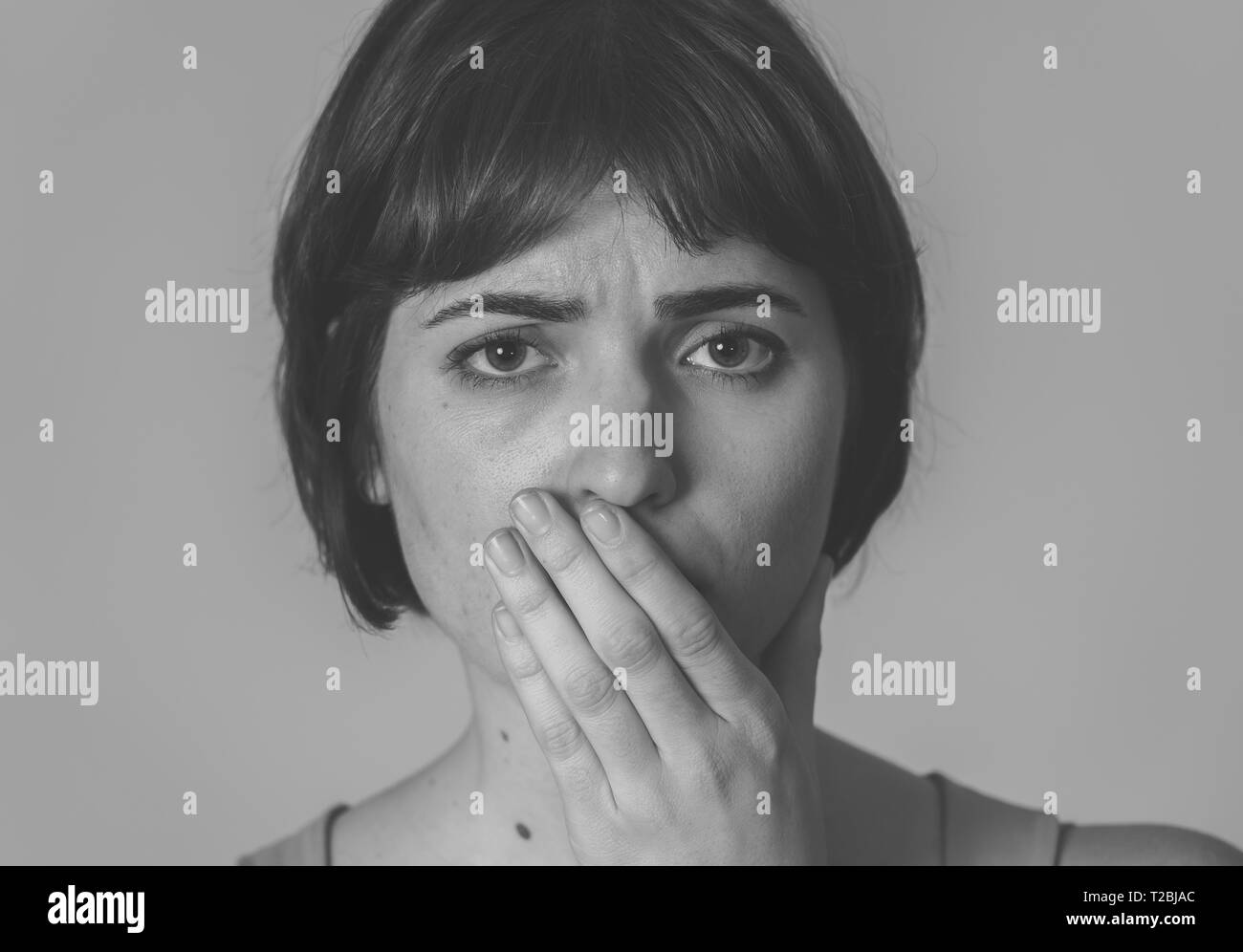 Bianco e nero ritratto di giovane donna triste, seri e interessati, guardando preoccupato e pensieroso. Sensazione di dolore e la depressione. Isolato in posizione neutrale Foto Stock