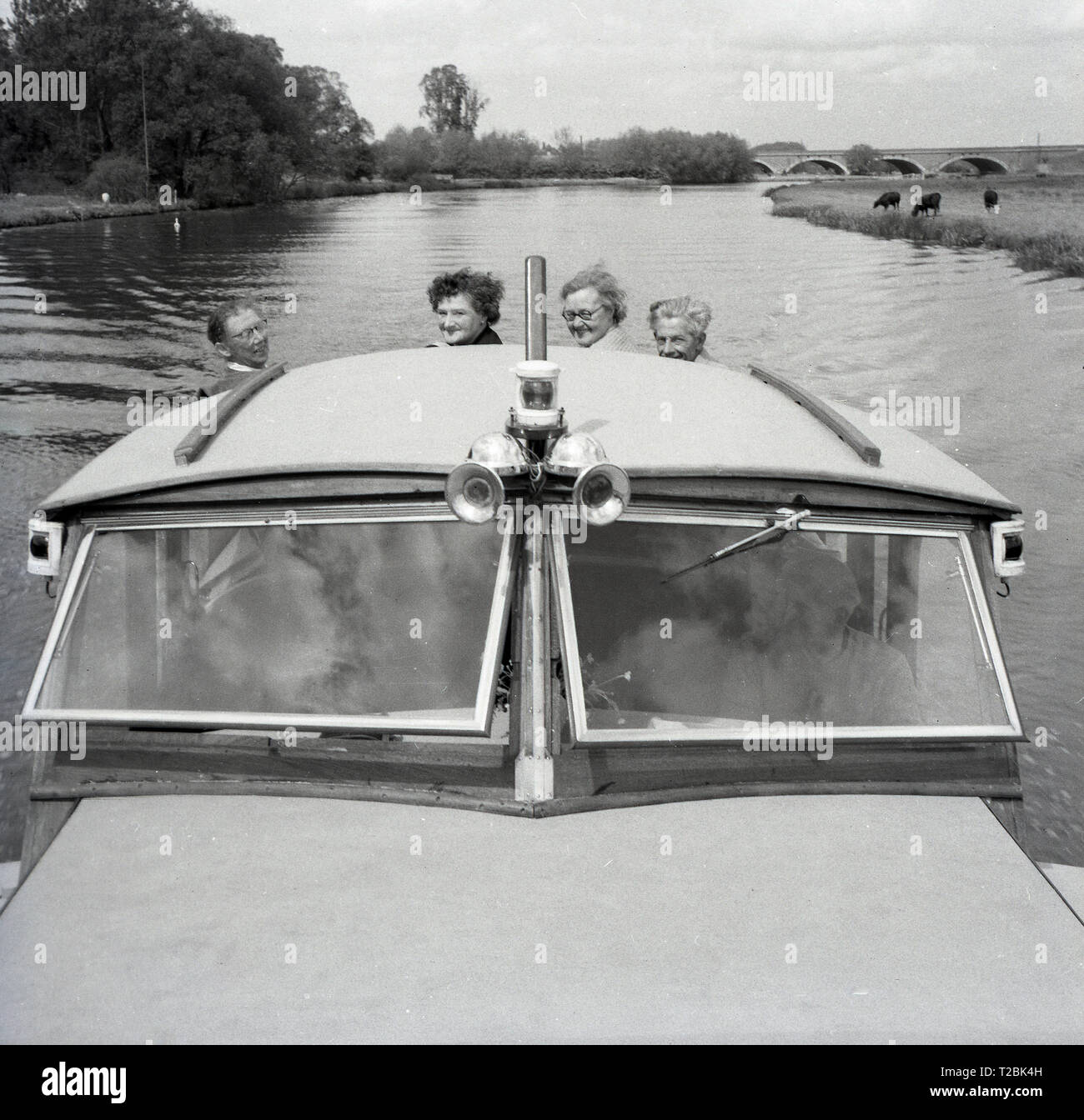Degli anni Cinquanta, storico, due coppie mature su un motore di lancio o cabina crusier scendendo lungo il corso del fiume Tamigi a Oxford, Inghilterra, Regno Unito. Foto Stock