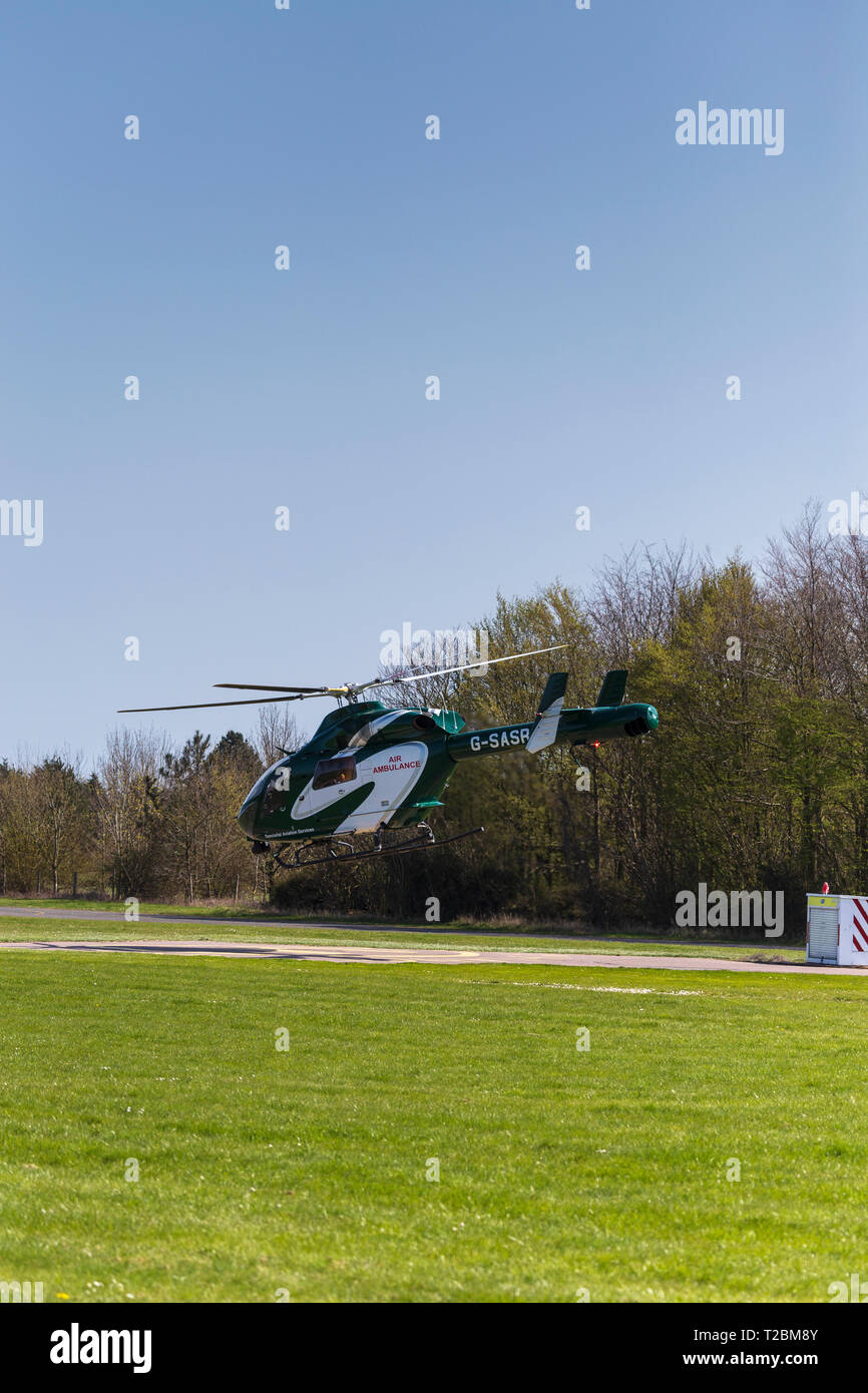 Funzionamento in elicottero per Essex & Herts Air Ambulance decollare da Earls Colne Aerodrome in Essex in una bella giornata di primavera Foto Stock