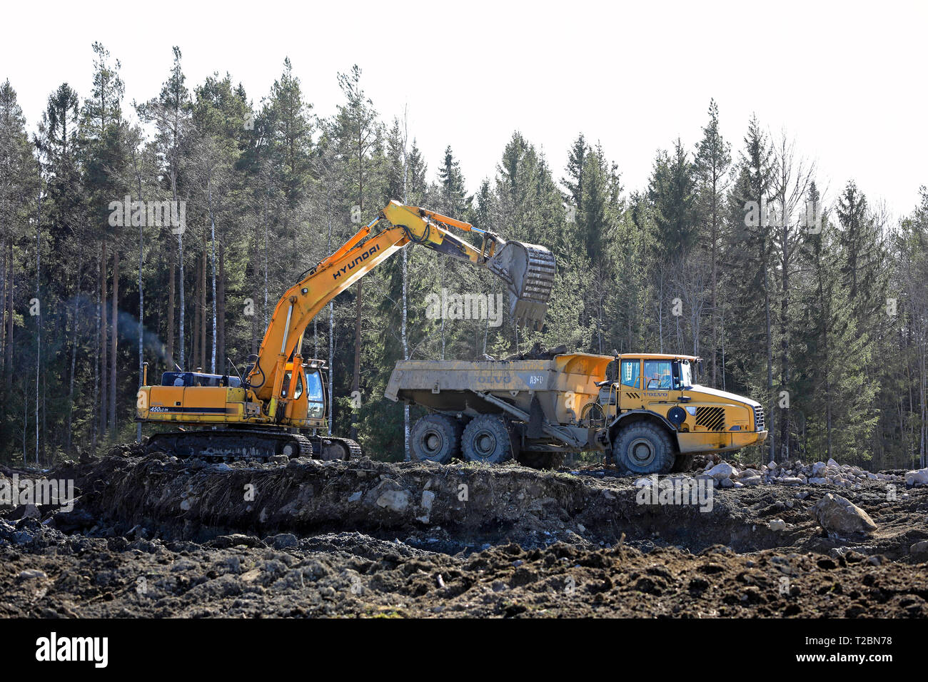 Lieto, Finlandia - 22 Marzo 2019: Hyundai Robex 450 LC carichi di escavatori Volvo A35D trasportatore articolato in corrispondenza di un sito in costruzione in Finlandia il giorno di primavera Foto Stock