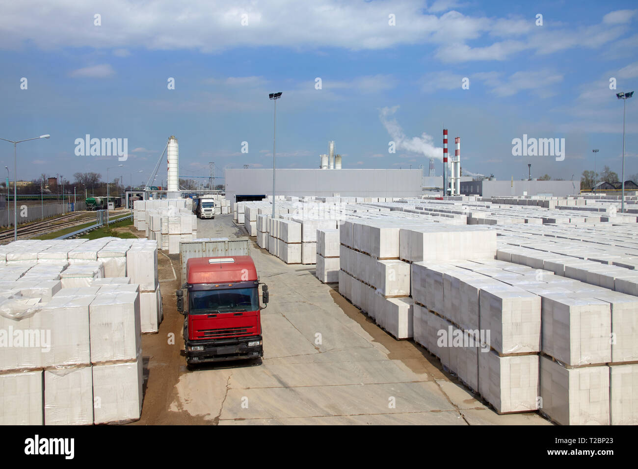 Vista della fabbrica di produzione di vegetali autoclavato calcestruzzo aerato. Molti pacchetti di blocchi su pallet mettere uno sull'altro in un magazzino esterno. Carrello ri Foto Stock